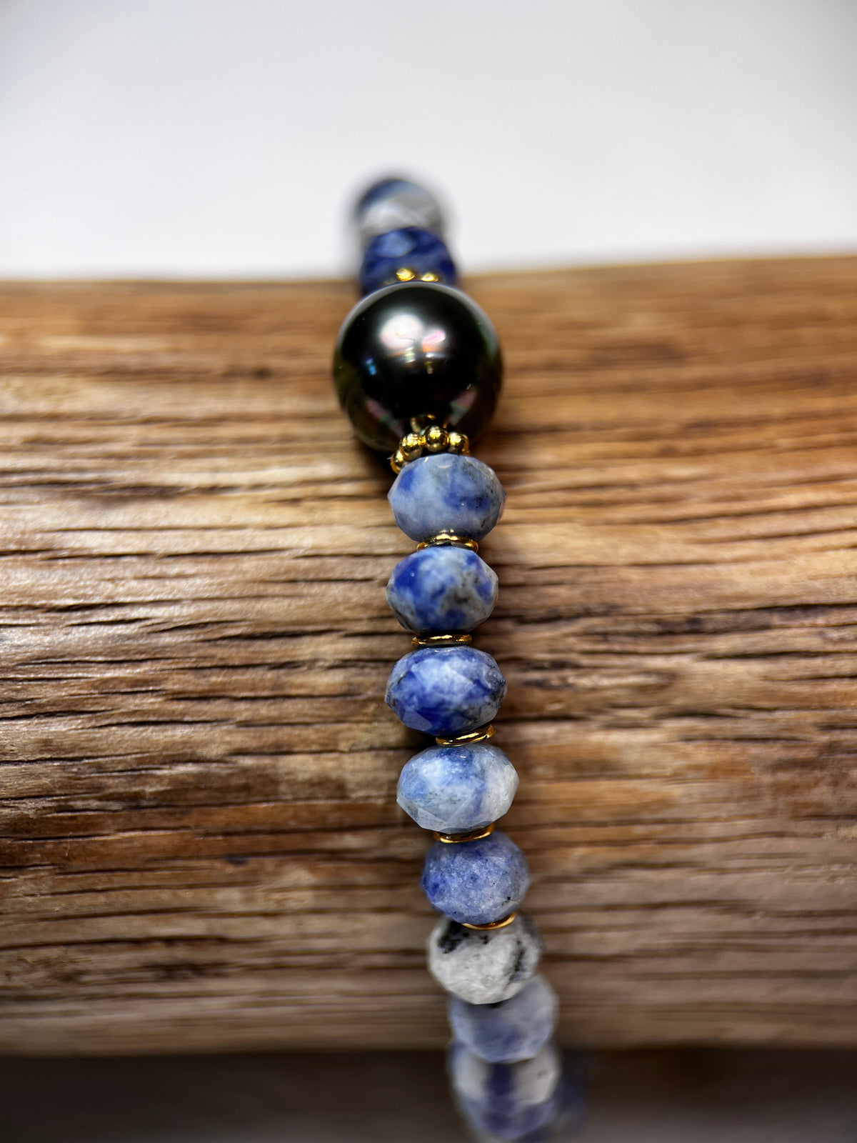 Les pierres sodalites bleues et blanches s’harmonisent avec la perle de Tahiti pour créer le bracelet mixte Vai