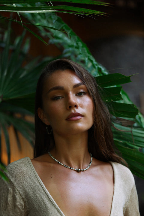 Creation de l’atelier Arima porté par notre mannequin  . Collier en pierres semi-précieuses de préhnite  aux tons variés de verts et perle de Tahiti aux reflets verts 